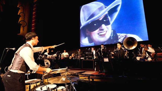 Beat that: Composer Ben Walsh and orchestra with Fearless Nadia in <em>Diamond Queen</em> on screen.