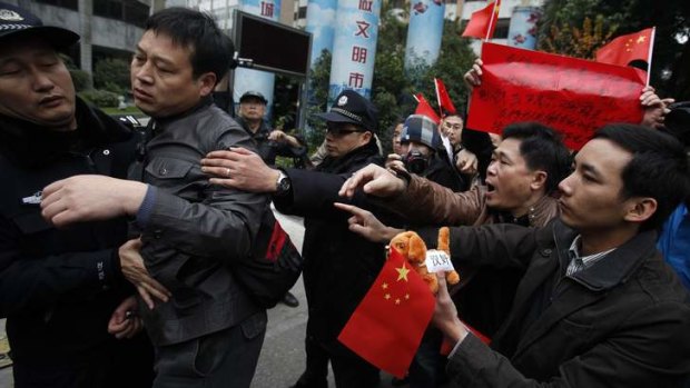 Street clashes ... policemen separate supporters of the Southern Weekly paper confronted by protesting leftists who denounced the publication as "a traitor newspaper" for defying the party.