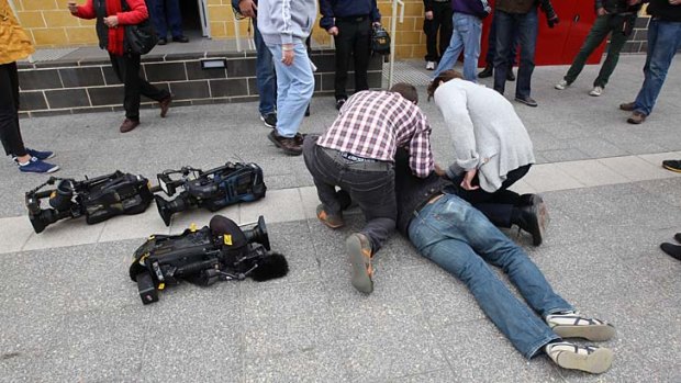 The cameraman receives attention after being pushed over.