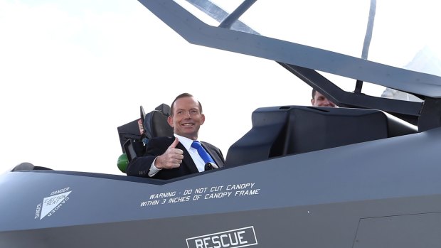 Former Prime Minister Tony Abbott poses for photos in the cockpit of a replica of a F-35A Lightning II Joint Strike Fighter in 2014. 