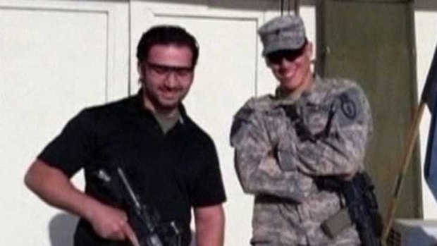 Amir Mirzaei Hekmati holds a weapon with US soldiers in this undated still image taken from video in an undisclosed location and supplied to Reuters.