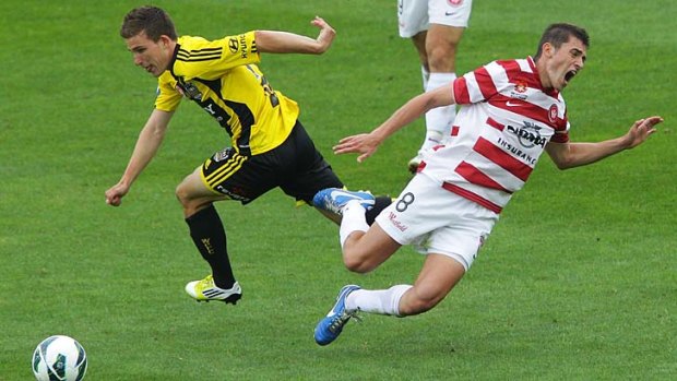 Collision &#8230; Louis Fenton of Wellington Phoenix and Western Sydney's Mateo Poljak get in a tangle. Wellington climbed three places to fifth on the ladder.