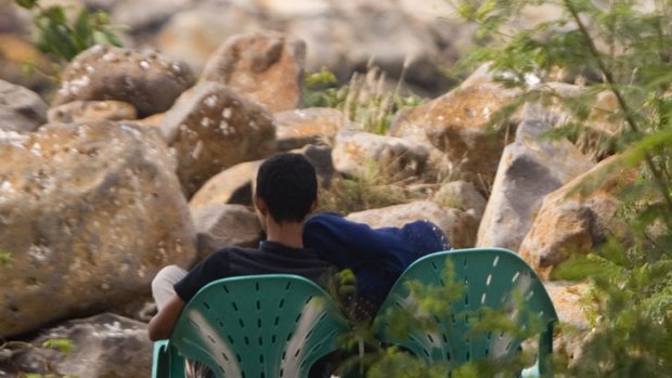 Illicit tryst ... a couple cuddle at the Ulele beachfront despite the attentions of local police.