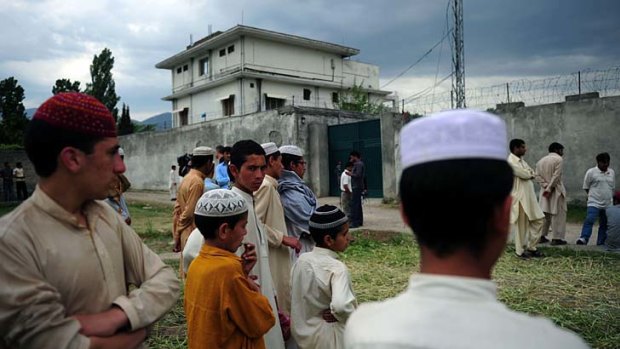 Pakistani students gather outside the final hiding place of Osama bin Laden in Abbottabad