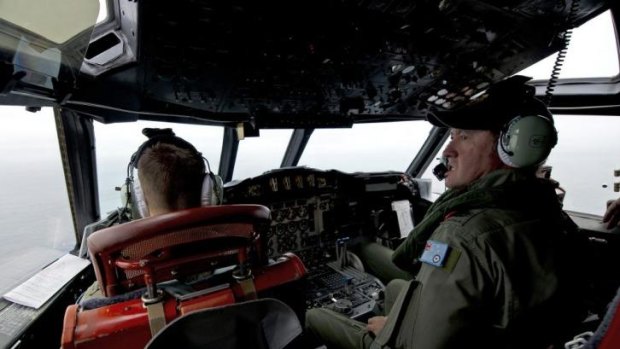 Royal Australian Air Force Flight Engineer, Warrant Officer Ron Day keeps watch for any debris as he flies in an AP-3C Orion over the Southern Indian Ocean.
