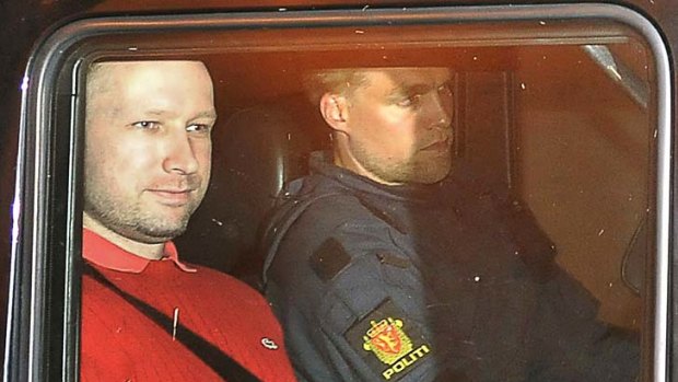 Pleaded not guilty to murder ... Anders Behring Breivik, left, leaves court in Oslo.