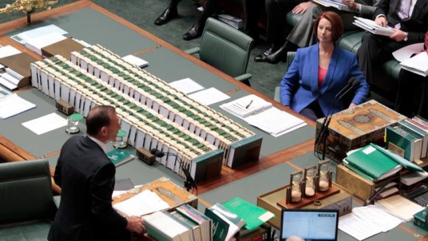 Prime Minister Julia Gillard listens to Opposition Leader Tony Abbott.