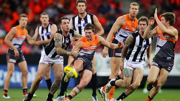 Just in time: Giant Taylor Adams clears the ball as Dane Swan grabs him — all to no avail as the Magpies countered every surge by GWS to win comfortably.
