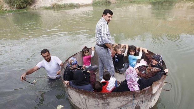 Fleeing ... a family from the Turkish village of Hacipasa crosses a river to escape the fighting.
