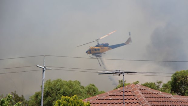 A helicopter drops water on the Jolimont fire.