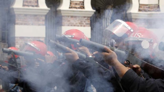 Malaysian riot police officers fire tear gas during a rally calling for electoral reforms in Kuala Lumpur.