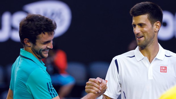All smiles: Novak Djokovic shakes hands with Gilles Simon after winning their fourth round match.