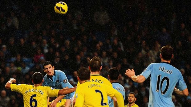 Manchester City's Gareth Barry climbs above Reading defenders to score his injury time winner.