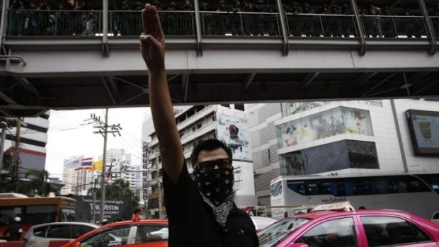 Gratitude, admiration and goodbye: a protester gives the three-finger salute during a demonstration outside a Bangkok shopping mall.