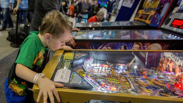 James Gee, 8, gets absorbed in a game at the NSW pinball championships.