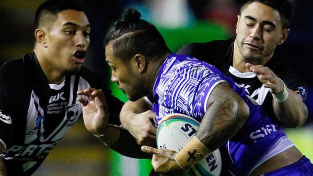 Defensive frailty: Shaun Johnson (R) tackles Junior Sa'u of Samoa.