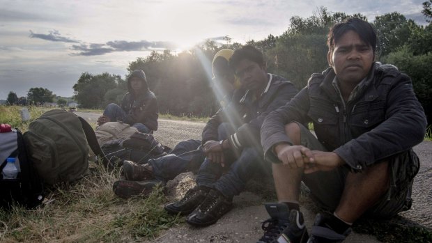 Migrants sit on the road between Hungary and Serbia near Szeged, Hungary.
