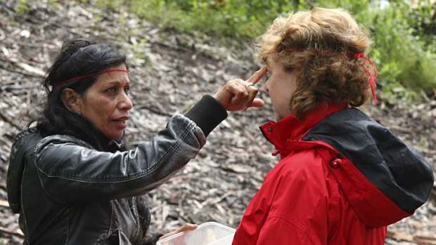Focus ... Aboriginal guide Lynne Thomas daubs ochre on a hiker's forehead.
