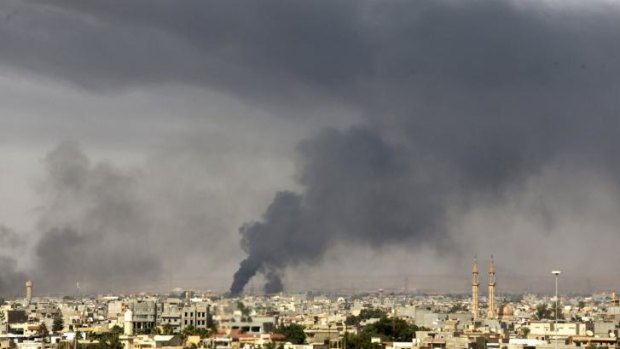 Smoke rises over Benghazi after clashes between militants, former rebel fighters and government forces.