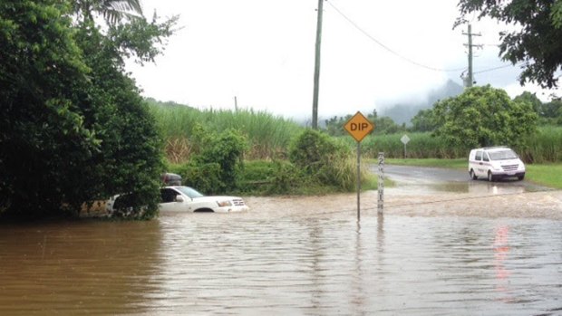 A couple has been rescued from floodwaters in north Queensland after their four-wheel-drive was washed from a causeway.