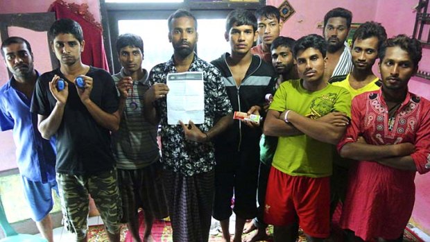 Bangladeshi asylum seekers back in their home in Cisarua, West Java, after being held on Australian ships for five days then send back on an Australian life-boat. Some hold the papers given to them by Customs officers, others hold the wrist bands they wore on the Australian ships.