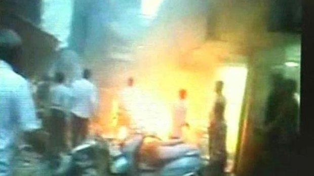 A frame grab from Indian television channel NDTV shows bystanders responding to a fire after a suspected bomb blast in Mumbai.