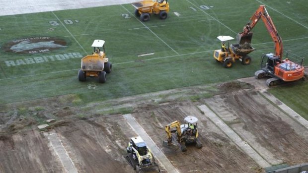 Patchwork: Diggers begin ripping up the turf at ANZ Stadium on Tuesday. 