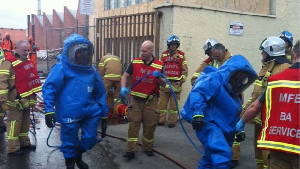 Firefighter don protective clothing to contain the chemical leak.