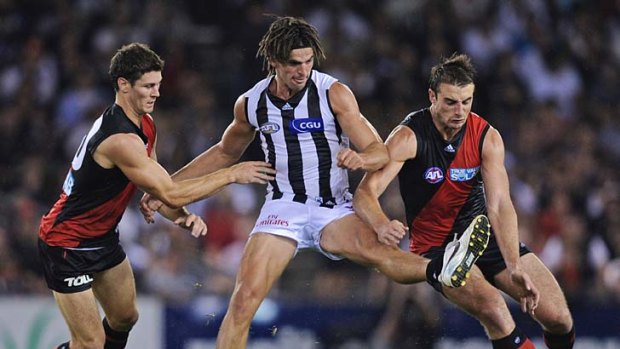 Essendon's Michael Hibberd and Jobe Watson try to prevent Collingwood's Scott Pendlebury taking control of the ball during the NAB cup final last year.