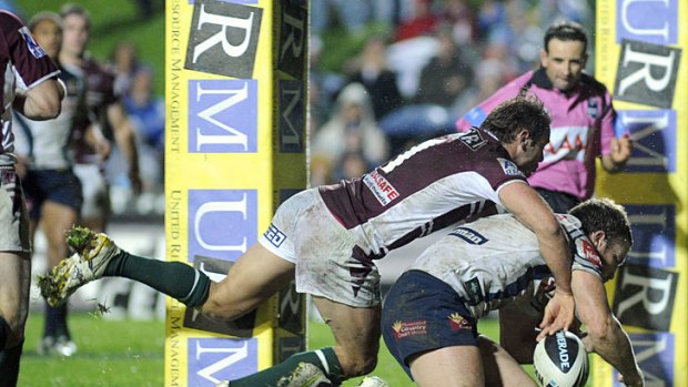 Manly fullback Brett Stewart goes for a tackle in goal.