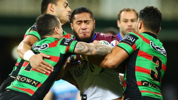 Jorge Taufua is wrapped up by the Souths defence.