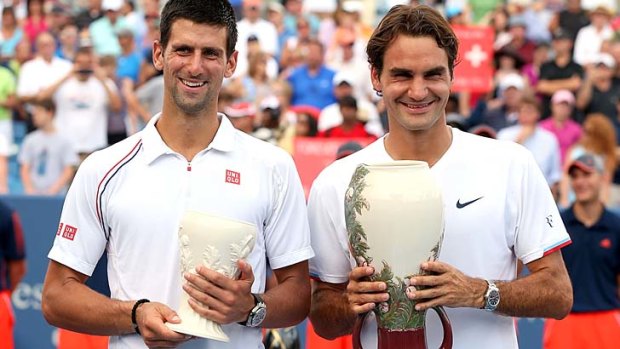 Novak Djokovic of Serbia and Roger Federer of Switzerland pose for photographers after the trophy ceremony during the final of the Western & Southern Open.
