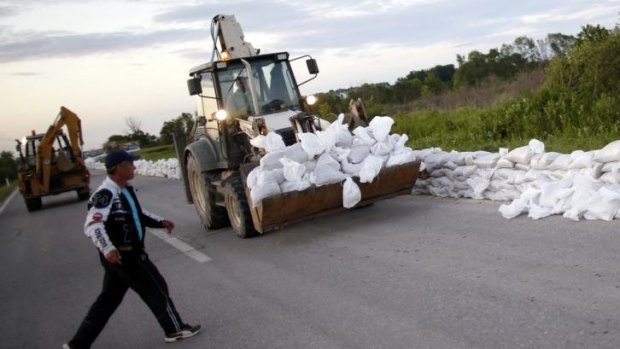 Sandbags are piled up along the side of a road near Orasje, Bosnia. Rescue teams from around Europe and thousands of local volunteers are evacuating people and building flood defences after the River Sava, swollen by days of torrential rain, burst its banks.
