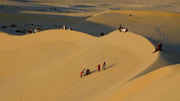 Residents walk on sand dunes near the Libyan desert oasis town of Ghadames.