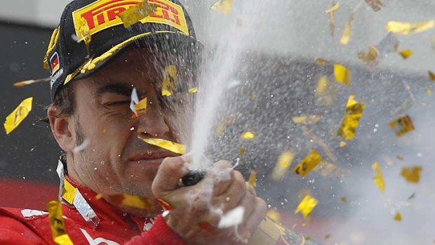 Celebration ... Fernando Alonso pops the cork.