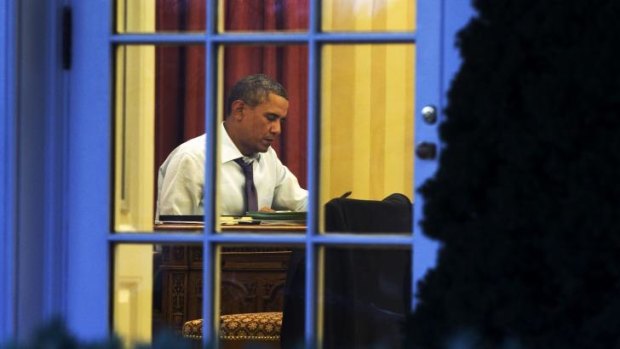 Last minute preparations: As seen from the Rose Garden, President Barack Obama works at his desk in the Oval Office of the White House in Washington on Monday ahead of Tuesday night's State of the Union speech.