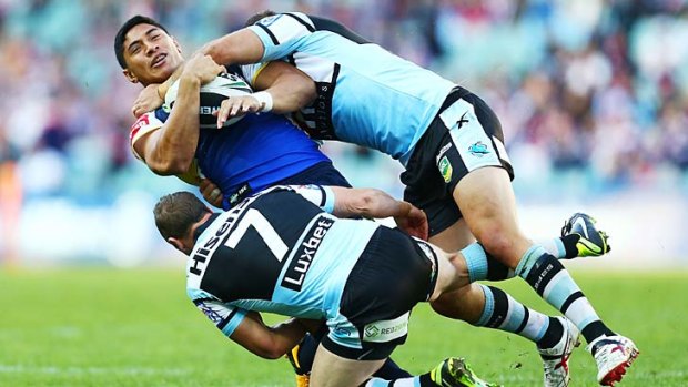 Collared: North Queensland's Jason Taumalolo is tackled by Cronulla Sharks players at Allianz Stadium on Saturday.