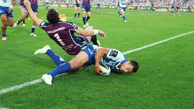 One-off ... Billy Slater flies over Sam Perrett as he scores the Bulldogs' only try of the day. James Graham's alleged bite on Slater's ear came seconds later.