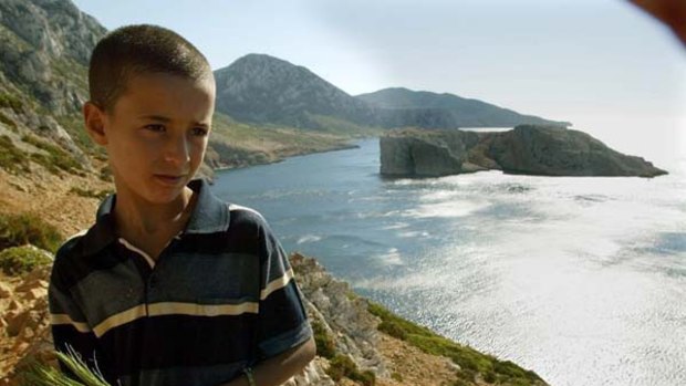 A Moroccan boy stands on the Moroccan coast in front of the disputed islet Perejil, which is claimed by Morocco and Spain.