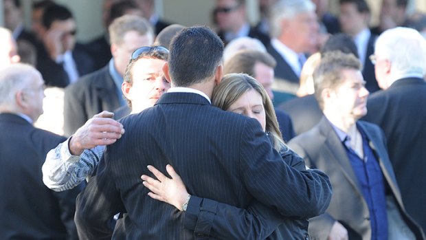 Friends and family console each other at Anthony Dunning's funeral last year.