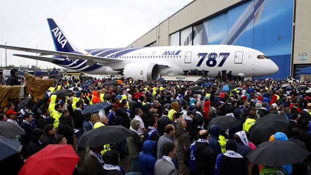 Boeing employees gather under umbrellas as All Nippon Airways (ANA) receive their first Boeing 787 in Everett yesterday.