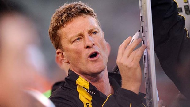 Damien Hardwick outlines strategy to his players during a break.