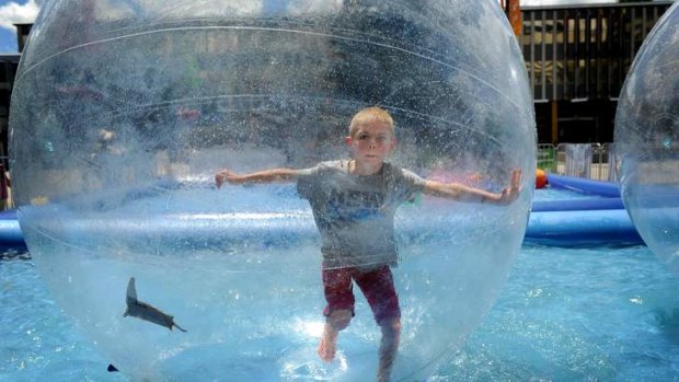 Noah Cross, 6, plays in the floating bubble that has been set up in Civic Square.