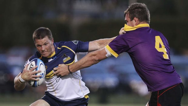 Clyde Rathbone is tackled by Gareth Clouston of the ACT XV during the Super Rugby trial match.