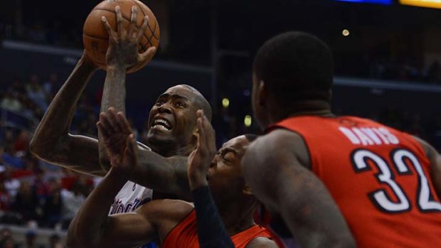 Jamal Crawford (left) of the Los Angeles Clippers drives on Terrence Ross and Ed Davis (32) of the Toronto Raptors.