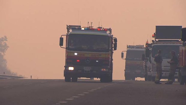 A fire truck drives up a smoky Brisbane's Centenary Highway.
