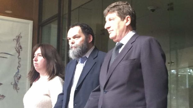 Daniel Hayman, centre, who has pleaded guilty to indecent assault of a child, outside Downing Centre local court on Tuesday.