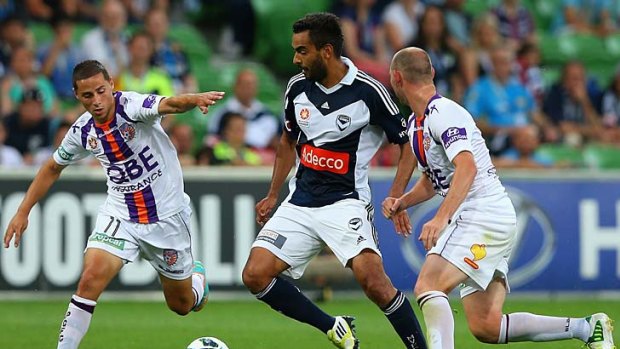 Victory's Marcos Flores (centre) looks to pass during the match against Perth Glory.