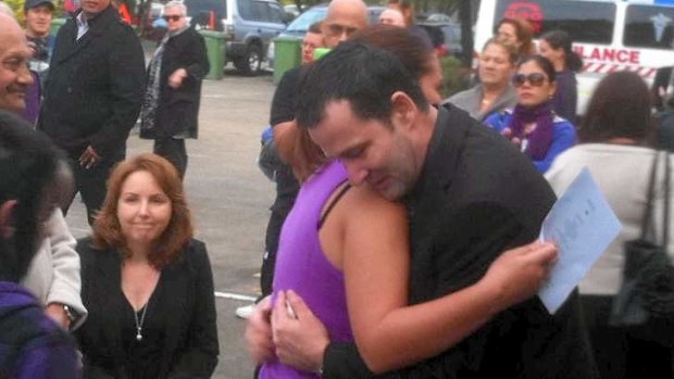 Cory Ryther is comforted at a vigil for his wife Joan Ryther, who was killed in Logan.