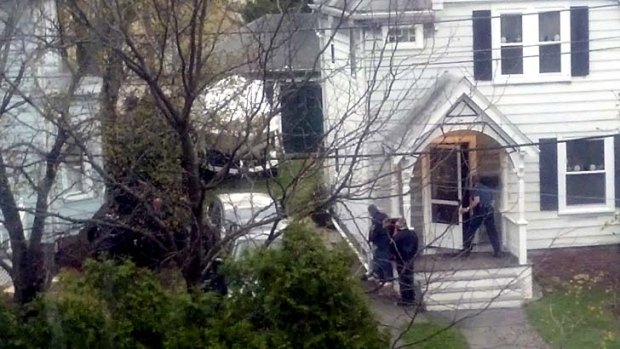 Search: Law enforcement agents look around the corner of a house where Boston Marathon bombing suspect Dzhokhar Tsarnaev was believed to be hiding in Watertown, Massachusetts.